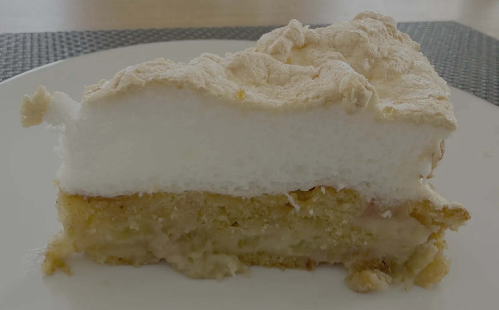Angeschnittenes Stück Rhabarber-Baiser-Kuchen auf einem Teller